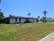 Attractive single-story home with well-kept lawn, fresh landscaping, and a welcoming front entrance at 20295 Lorenzo Ave, Port Charlotte, FL 33952