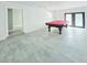Bright game room features a pool table, gray floors, white walls and access to the patio at 20295 Lorenzo Ave, Port Charlotte, FL 33952