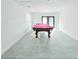 Bright game room features a pool table, gray floors, white walls and access to the patio at 20295 Lorenzo Ave, Port Charlotte, FL 33952