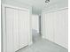 Bright hallway with grey tile flooring and white doors, offering ample storage and clean, minimalist design at 20295 Lorenzo Ave, Port Charlotte, FL 33952