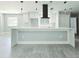 Bright kitchen features an island with a white countertop, sleek white cabinetry, and modern pendant lighting at 20295 Lorenzo Ave, Port Charlotte, FL 33952