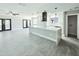 Modern open-concept kitchen and living area featuring an island with a white countertop and black framed glass doors at 20295 Lorenzo Ave, Port Charlotte, FL 33952