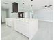 Stylish kitchen with white cabinets, modern island, and black range hood providing an open and airy space at 20295 Lorenzo Ave, Port Charlotte, FL 33952