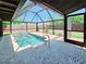 Outdoor screened-in pool with brick pavers and lush green landscaping at 20295 Lorenzo Ave, Port Charlotte, FL 33952