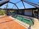 Outdoor screened-in pool with brick pavers and lush green landscaping at 20295 Lorenzo Ave, Port Charlotte, FL 33952