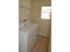 Efficient laundry room with washer, dryer, shelving, and a window to give a well-lit and organized space at 20420 Carolina Cherry Ct, Tampa, FL 33647