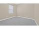 A bedroom with neutral walls and gray carpet with a window that provides natural light at 215 S Westland Ave # 3, Tampa, FL 33606