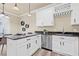 Modern kitchen featuring white cabinets, dark countertops, stainless steel appliances, and stylish pendant lighting at 215 S Westland Ave # 3, Tampa, FL 33606