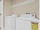 Bright laundry room with a washer, dryer, and overhead shelving at 215 S Westland Ave # 3, Tampa, FL 33606
