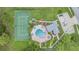 Aerial shot showcases a community pool, a tennis court, parking, and green landscaping at 2355 Bentley Dr, Palm Harbor, FL 34684