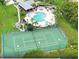 An aerial view showcasing a community pool, spa, clubhouse, and tennis courts surrounded by lush landscaping at 2355 Bentley Dr, Palm Harbor, FL 34684