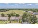 An aerial view shows the property near an open field with mature trees, and a parking area at 2355 Bentley Dr, Palm Harbor, FL 34684