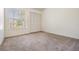 Bedroom featuring plush carpet, a window, and a closet at 2355 Bentley Dr, Palm Harbor, FL 34684