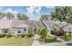 Charming single-story home featuring a well-manicured lawn, mature landscaping, and inviting front entryway at 2355 Bentley Dr, Palm Harbor, FL 34684