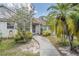 Inviting front entrance with a curved walkway, beautiful landscaping, and a charming exterior at 2355 Bentley Dr, Palm Harbor, FL 34684