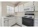 Kitchen featuring white cabinetry, countertops and appliances with a window view at 2355 Bentley Dr, Palm Harbor, FL 34684