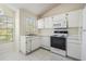 Bright kitchen with white appliances and cabinetry and plenty of sunlight at 2355 Bentley Dr, Palm Harbor, FL 34684