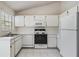 Kitchen with white cabinetry, standard appliances, and tile flooring at 2355 Bentley Dr, Palm Harbor, FL 34684