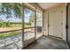 A screened patio featuring a concrete floor, and an exterior door leading to the backyard at 2355 Bentley Dr, Palm Harbor, FL 34684