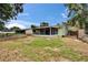 A large back yard featuring a screened-in patio, manicured lawn, and secure fencing at 2415 Devonwoode Pl, Seffner, FL 33584