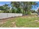 A spacious back yard featuring a white fence for privacy and mature trees at 2415 Devonwoode Pl, Seffner, FL 33584
