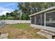 View of the backyard, featuring a screened-in porch, a fenced perimeter, and grass at 2415 Devonwoode Pl, Seffner, FL 33584