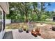 Backyard features mature trees, a fenced perimeter, and a stone firepit area at 2415 Devonwoode Pl, Seffner, FL 33584