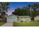 Charming single-story home with green exterior, manicured lawn, and attached one car garage at 2415 Devonwoode Pl, Seffner, FL 33584