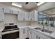 Bright kitchen featuring white cabinets, modern countertops, and stainless steel appliances at 2415 Devonwoode Pl, Seffner, FL 33584