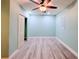 Bedroom with light blue walls featuring a ceiling fan and closet with white door at 2432 Caretta Ave, Spring Hill, FL 34609