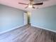 Spacious bedroom has modern floors, a ceiling fan, with a white door to the hall and closet at 2432 Caretta Ave, Spring Hill, FL 34609
