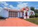 Charming single-story home showcasing its unique architectural style with an arched entryway and colorful accents at 2432 Caretta Ave, Spring Hill, FL 34609