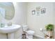 Bathroom features a pedestal sink, a toilet with floral accents, and decorative artwork at 2723 Garden Falls Dr, Brandon, FL 33511
