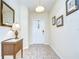 Welcoming entryway with tile flooring, a console table, decorative mirror, and elegant light fixture at 2723 Garden Falls Dr, Brandon, FL 33511