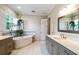 Inviting bathroom featuring a soaking tub, hanging plants, and double vanity for added convenience at 3109 W Granada St, Tampa, FL 33629