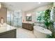 Luxurious bathroom featuring a glass shower, soaking tub, and modern vanity at 3109 W Granada St, Tampa, FL 33629