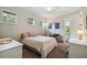 Bright bedroom with three windows, ceiling fan, cozy seating area, and neutral decor at 3109 W Granada St, Tampa, FL 33629