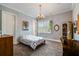 Bright bedroom with a floral bedspread, chandelier, and desk; well-lit by a large window at 3109 W Granada St, Tampa, FL 33629