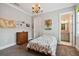 Well-lit bedroom featuring neutral walls, a floral bedspread, chandelier and view into the en-suite bathroom at 3109 W Granada St, Tampa, FL 33629
