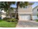 Charming two-story home boasts a large garage, brick driveway and lush landscaping with mature palm trees at 3109 W Granada St, Tampa, FL 33629