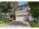 Charming two-story home boasts a large garage, brick driveway and lush landscaping with mature palm trees at 3109 W Granada St, Tampa, FL 33629