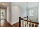 Well-lit hallway with hardwood floors, leading to staircase and other areas of the home at 3109 W Granada St, Tampa, FL 33629