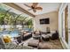 Enclosed patio with a ceiling fan, wicker seating, brick floors, a fire pit, and pool views at 3109 W Granada St, Tampa, FL 33629