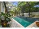 Enclosed pool with brick patio, mosaic tile trim, lush landscaping, and screened enclosure at 3109 W Granada St, Tampa, FL 33629