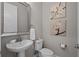 Stylish half-bathroom with a pedestal sink and decorative wall art at 3161 Satilla Loop, Odessa, FL 33556