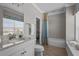 Well-lit bathroom with granite countertop, stylish fixtures, and a tub with shower at 3161 Satilla Loop, Odessa, FL 33556