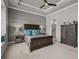 Well-lit bedroom features a tray ceiling, ceiling fan, and a comfortable gray and brown aesthetic at 3161 Satilla Loop, Odessa, FL 33556