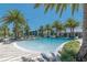 Resort-style community pool with palm trees, lounge chairs, and modern clubhouse in the background at 3161 Satilla Loop, Odessa, FL 33556