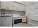Convenient laundry room with modern washer, dryer, and ample storage cabinets at 3161 Satilla Loop, Odessa, FL 33556