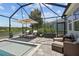 Relaxing screened pool area with sun umbrella, lounge chairs and cushioned outdoor seating at 3161 Satilla Loop, Odessa, FL 33556